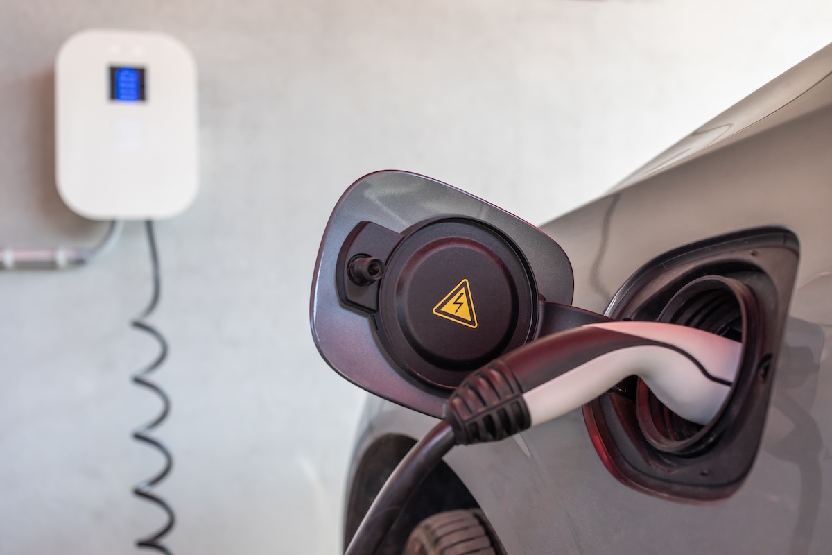An electric vehicle charger plugged into a car's charging port.